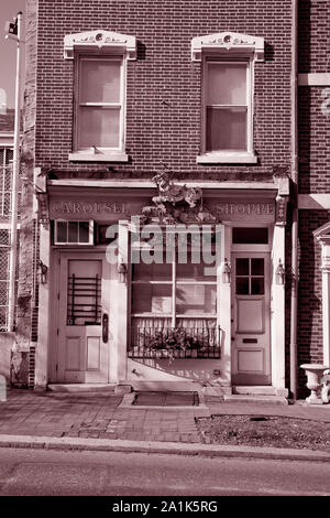 Giostra Shoppe nel vecchio edificio di Philadelphia. Verticale fotografia seppia con scolpito giostra cavallo sopra le porte. Foto Stock