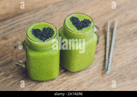 Frullato verde fresco con banana e spinaci con cuore di semi di sesamo. Amore per un sano concetto di cibo crudo Foto Stock