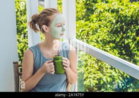 Spa Donna applicazione viso verde argilla maschera. Trattamenti di bellezza. Frullato verde fresco con banana e spinaci con cuore di semi di sesamo. Amore per un Foto Stock