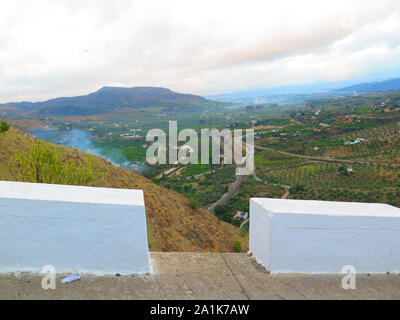 Panorama che si vede attraverso il cemento bianco paracarri sulla strada si affaccia vallata a Alora Castle Hill Foto Stock