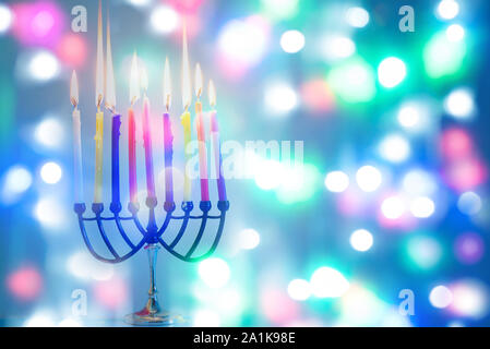 Immagine della festa ebraica Hanukkah felice su sfondo colorato con menorah tradizionale candelabri e candele accese. Foto Stock