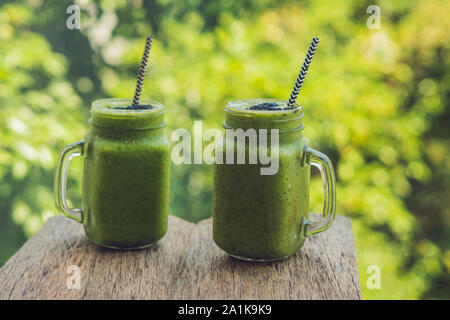 Frullato verde fresco con banana e spinaci con cuore di semi di sesamo. Amore per un sano concetto di cibo crudo Foto Stock