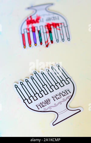 L'immagine verticale due fogli di carta il menorah e candela dipingere con la penna a colori. Festa ebraica Chanukah. Testo ebraico : Happy Hanukkah. Foto Stock