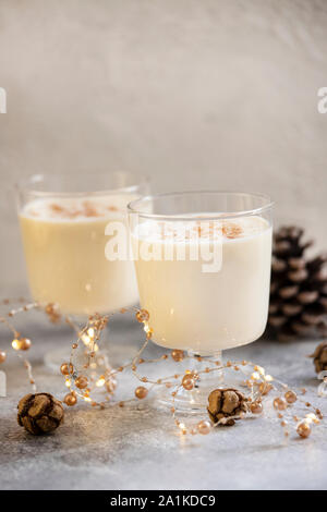 Zabaione tradizionali fatti in casa Natale e Anno Nuovo drink con la cannella e la noce moscata. Vacanze invernali dell'umore. Sfondo chiaro. Messa a fuoco selettiva. In verticale Foto Stock