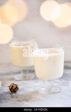 Zabaione tradizionali fatti in casa Natale e Anno Nuovo drink con la cannella e la noce moscata. Vacanze invernali dell'umore. Sfondo chiaro. Messa a fuoco selettiva. In verticale Foto Stock