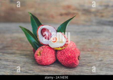 Frutta di litchi fresca su un vecchio sfondo di legno Foto Stock