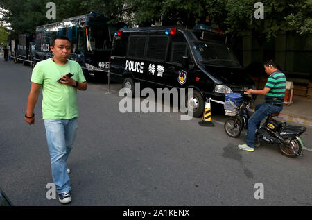 Pechino, Cina. Il 27 settembre, 2019. Il cinese a piedi passato una fila di poliziotti antisommossa veicoli parcheggiati nel centro cittadino di Pechino il Venerdì, 27 settembre 2019. La capitale è su lockdown come sono in corso i preparativi per il 1 ottobre il settantesimo anniversario della RPC, che includono una parata militare. Foto di Stefano rasoio/UPI Credito: UPI/Alamy Live News Foto Stock