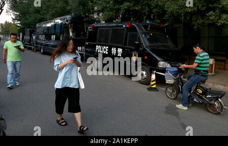 Pechino, Cina. Il 27 settembre, 2019. Il cinese a piedi passato una fila di poliziotti antisommossa veicoli parcheggiati nel centro cittadino di Pechino il Venerdì, 27 settembre 2019. La capitale è su lockdown come sono in corso i preparativi per il 1 ottobre il settantesimo anniversario della RPC, che includono una parata militare. Foto di Stefano rasoio/UPI Credito: UPI/Alamy Live News Foto Stock