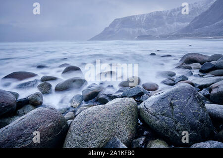 Le onde del mare di Norvegia agitandosi su rocce di pietra. Esposizione lunga Foto Stock