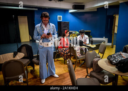 Elvis' attendere che si preparano per la concorrenza all'interno del Grand Pavillion all annuale Porthcawl festival di Elvis in Galles del Sud. La manifestazione richiama migliaia di fan di Elvis alla Welsh cittadina balneare per celebrare il Re del Rock and Roll'. Foto Stock