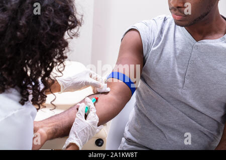 Close-up di medico tenendo campione di sangue dal braccio del paziente Foto Stock