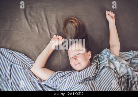 Bella giovane donna sdraiata a letto e dormiente, vista dall'alto. Non ottenga abbastanza concetto di sonno Foto Stock