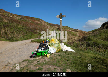 Cestino di plastica e raccolti in una comunità raccolta differenziata dei rifiuti nei pressi di cartello su Wales coast Path Marloes Pembrokeshire Wales UK KATHY DEWITT Foto Stock