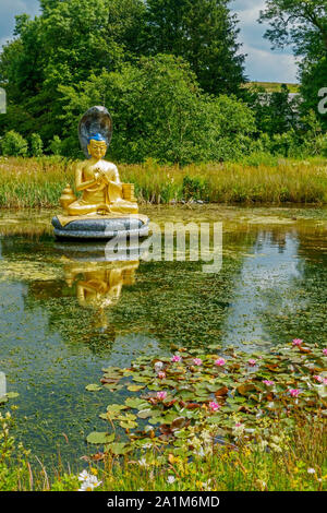 Statua del dio buddista Nagarjuna in uno stagno al Kagyu Samye Ling Monastero e centro tibetano in Eskdalemuir, Dumfries and Galloway, Scozia. Foto Stock