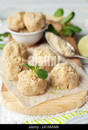 Materie vegane cocco e amaretti di lime sul tagliere di legno. I cookie di sani Foto Stock