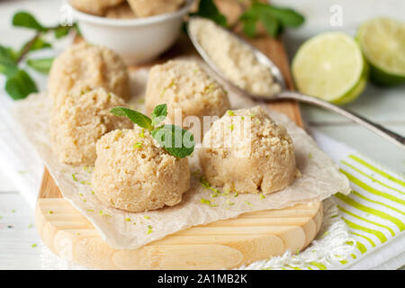 Materie vegane cocco e amaretti di lime sul tagliere di legno. I cookie di sani Foto Stock