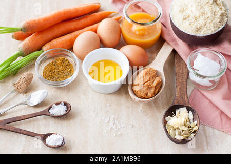 Carote, purea di zucca e semi, farina di mandorle di noce di cocco, burro, uova, spezie. Ingredienti per senza glutine di zucca e muffin alla carota Foto Stock