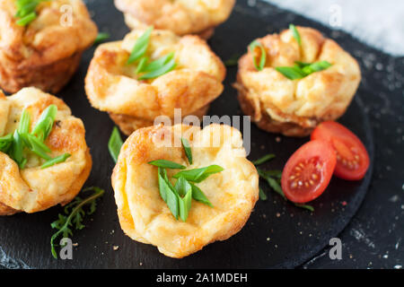 Senza glutine muffin uovo con funghi e formaggio molle sulla piastra di ardesia. Una sana prima colazione Foto Stock