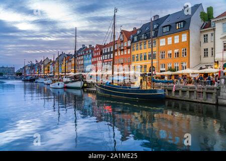 Una vista serale di colorate case a schiera lungo un canale nel quartiere di Nyhavn di Copenhagen, Danimarca. Foto Stock