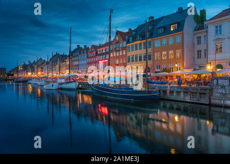 Una vista serale di colorate case a schiera lungo un canale nel quartiere di Nyhavn di Copenhagen, Danimarca. Foto Stock