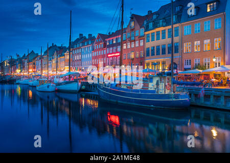 Una vista serale di colorate case a schiera lungo un canale nel quartiere di Nyhavn di Copenhagen, Danimarca. Foto Stock