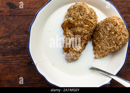 Tutto il chicco di frumento Cereali per la colazione in una ciotola con il latte Foto Stock