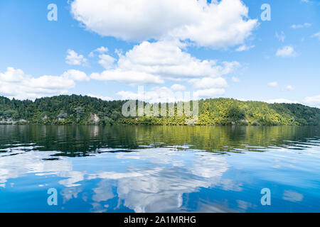 Riflette il lago di bordo e nuvole bianche su idilliaco Lago Rotoiti vicino a Rotorua Nuova Zelanda. Foto Stock