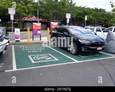 Una vista generale di una doppia EV stazione di parcheggio con una Tesla essendo caricato in Tropical North Queensland Foto Stock