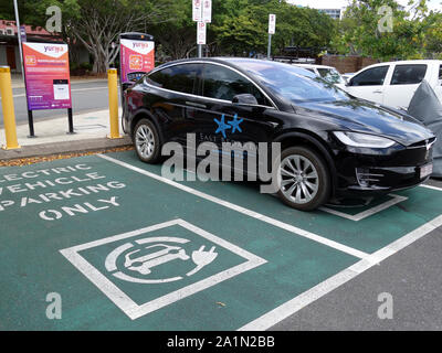 Una vista generale di una doppia EV stazione di parcheggio con una Tesla essendo caricato in Tropical North Quee Foto Stock