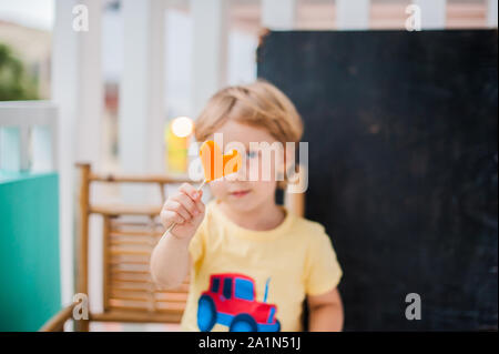 Ragazzo che beve frullato papaya. Concetto di cibo sano. Tavola di legno nero con spazio per il testo Foto Stock