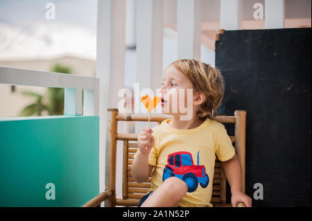 Ragazzo che beve frullato papaya. Concetto di cibo sano. Tavola di legno nero con spazio per il testo Foto Stock