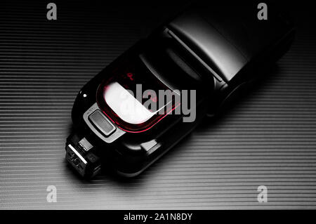 Esterno lampada a flash per fotocamera reflex digitale su sfondo scuro. Foto Stock