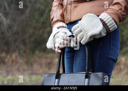 Donna che mantiene un portamonete durante l'autunno Meteo Foto Stock