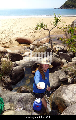 Offrendo una tazza di acqua dall'acqua fresca corrente a Turtle Bay, Cape Grafton, vicino a Cairns, Queensland, Australia. No signor o PR Foto Stock