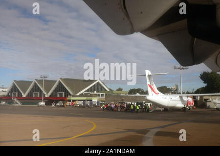 Persone su strada asfaltata in attesa di bordo piano, Ivato International Airport, Antananarivo, Madagascar. N. PR o MR Foto Stock