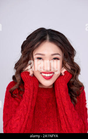 Ritratto di bellezza inverno ragazza asiatica in maglia rosso vestito di lana. Vacanze di Natale. Foto Stock