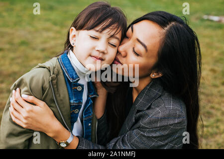 Madre figlia abbracciando e baciando Foto Stock