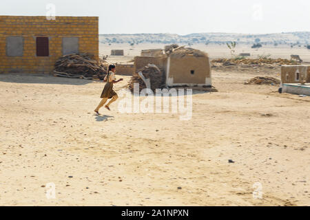 Jaisalmer, India - 14 Febbraio 2019: Indiano bambina corre nel villaggio tradizionale al deserto di Thar Foto Stock