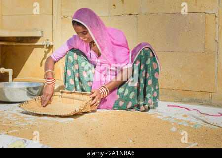 Jaisalmer, India - 16 Febbraio 2019: le donne indiane riso di pulizia sulla strada a Jaisalmer. Rajasthan Foto Stock