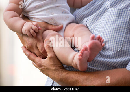 Un padre tiene un bambino tra le braccia Foto Stock