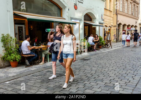 Persone, due donne in via Zelezna, turisti nella città vecchia di Praga Repubblica Ceca Coobbled acciottolato Foto Stock