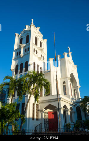 Luminoso vista panoramica di San Paolo chiesa episcopale (costruito nel 1919) in semplici in cemento bianco con palme di Key West, Florida, Stati Uniti d'America Foto Stock