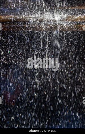 Gli spruzzi di acqua contro uno sfondo scuro Foto Stock
