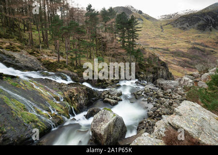 Bella immagine di panorama di Ogwen Valle del fiume e cascate durante il periodo invernale con cime innevate sullo sfondo Foto Stock