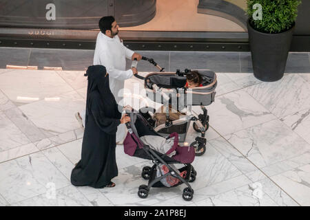 Arab giovane wheeling carrozzine con neonati, centro commerciale di Dubai, Emirati Arabi Uniti Foto Stock