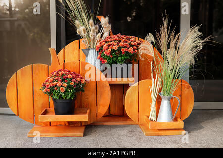 Orange in legno artigianali fatti a mano stile Halloween fiore-stand con crisantemo e erba essiccata fiori nella Casa Portico . Vacanze autunnali home decoration Foto Stock