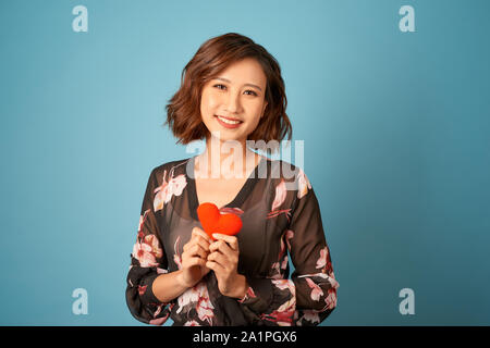 Amore dal primo sguardo. Donna in abito elegante tenere premuto il simbolo dell'amore. Foto Stock