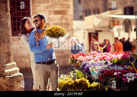 Coppia felice shopping per le piante al negozio di fiori sulla strada. Foto Stock