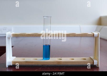 Legno di rack per provette con tubo a temperatura di ebollizione della soluzione di solfato di rame in un old school Science Laboratory. La scienza dell'educazione lab concept Foto Stock