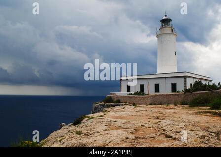 Lungi de La Mola, Faro sulla scogliera di Formentera. Nuvole scure all orizzonte annunciare un avvicinamento tempesta. Foto Stock